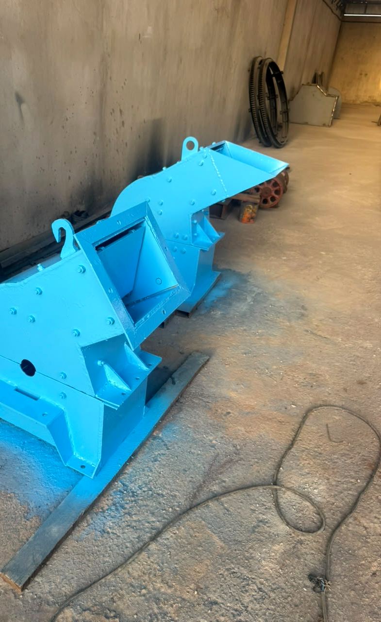 Deux carters peints en bleu posés au sol de l'atelier